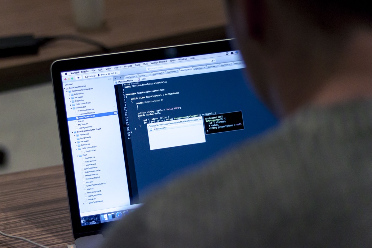 Programador trabajando de cerca en una laptop con código en pantalla